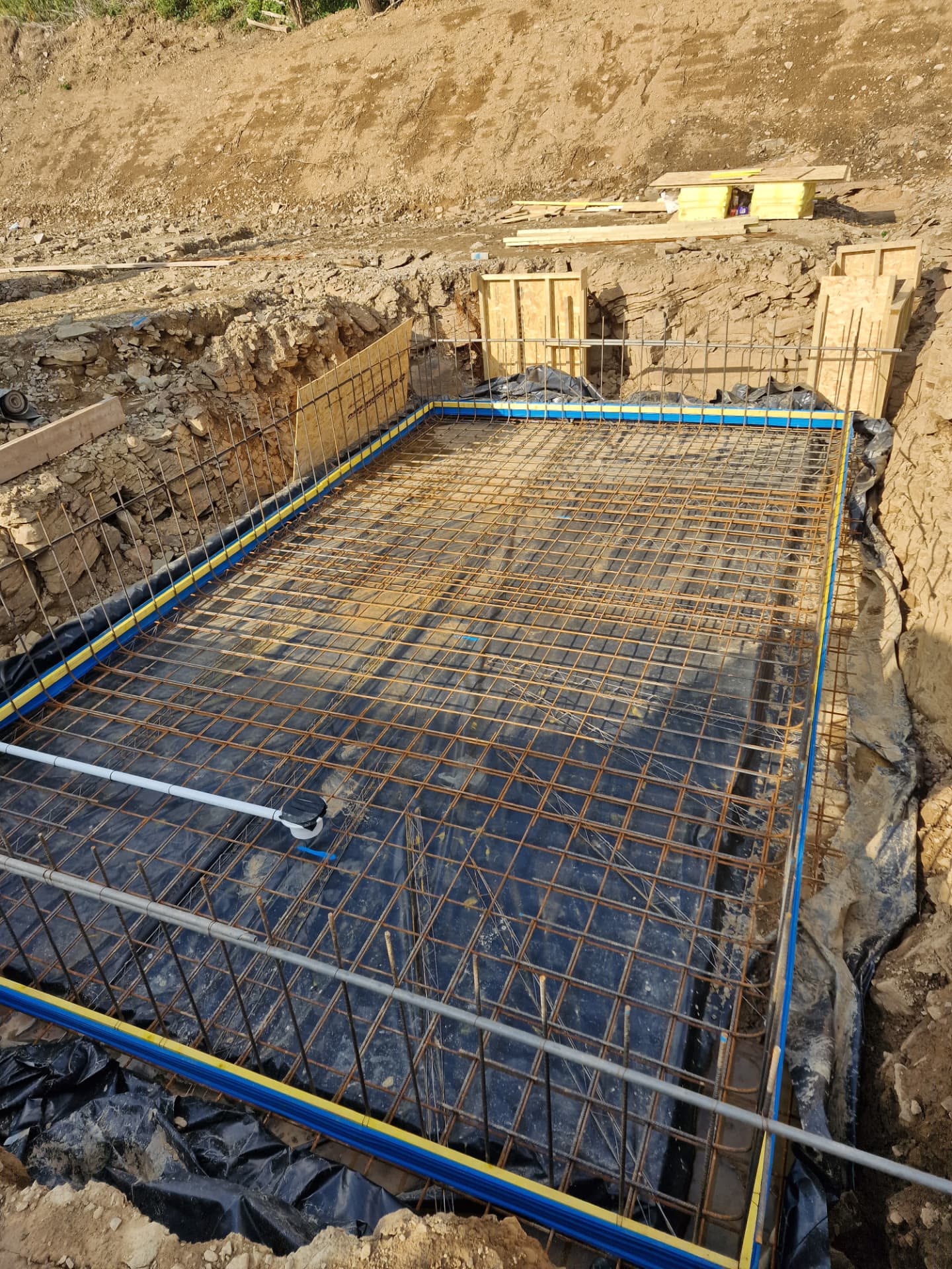 Excavator forming strip foundations with drainage laid on a South Wales plot